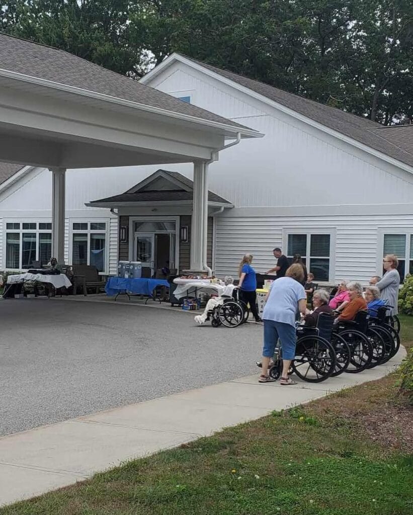 Residents and staff gathered outside the covered main entrance at Lakeshore Woods.