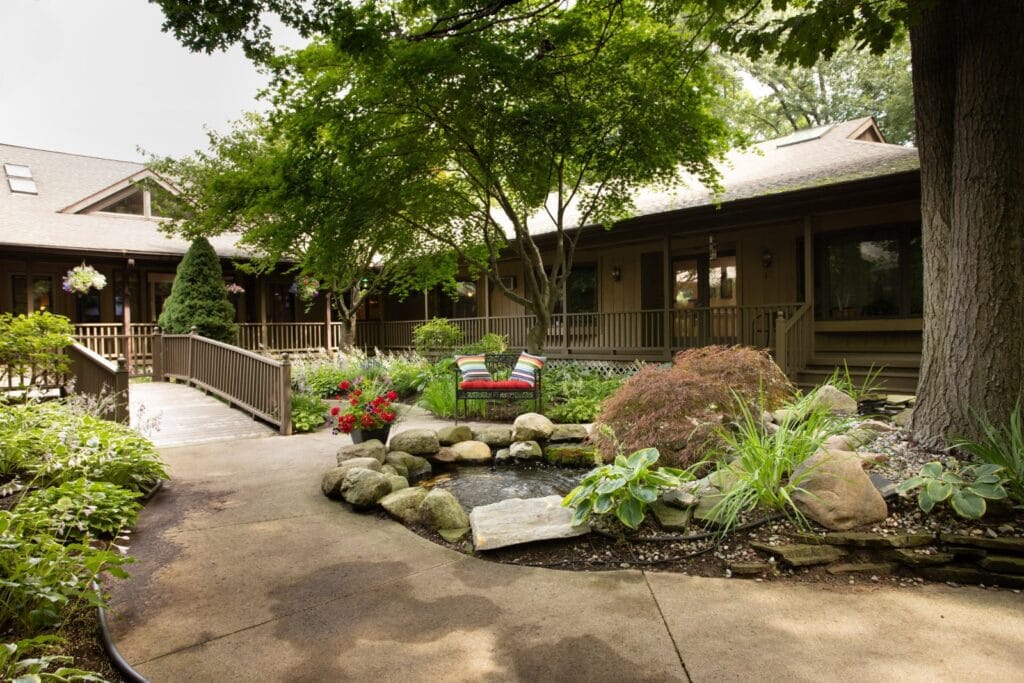 Landscaped rock garden and paved walkway outside Lakeshore Woods Senior Living.